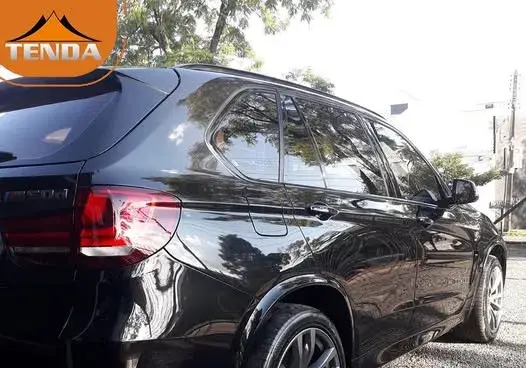 Farol automotivo oxidado e amarelado, isolado com fita de máscara antes do polimento na Tenda